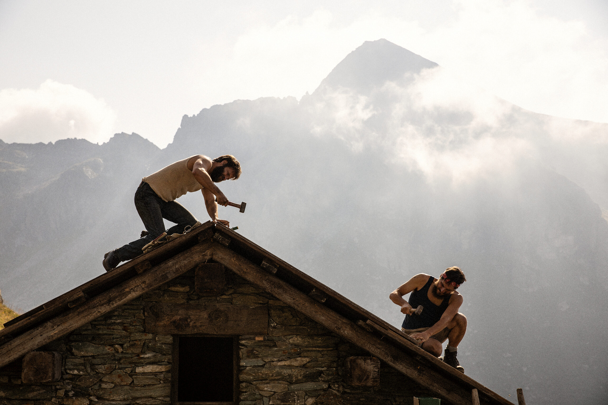 De acht bergen - twee mannen op het dak van een berghut